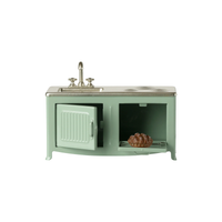 Mint green small vintage-style kitchen sink with cabinet on a white background.