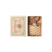 Small box containing a sleeping toy mouse.  Floral pattern inside a matchbox-style packaging on a white background.