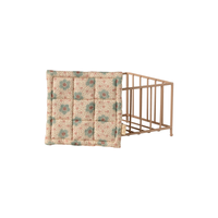 Metal playpen with floral-patterned quilt on a white background.