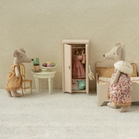 Miniature room setup with toy mice - one is the queen mouse - and furniture against a patterned wall.