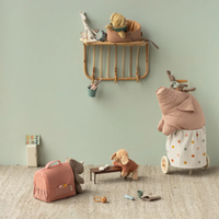 Toy children's room with stuffed toys and a shelf against a light green wall.  Animals include dogs, a pig, rhino and giraffe.