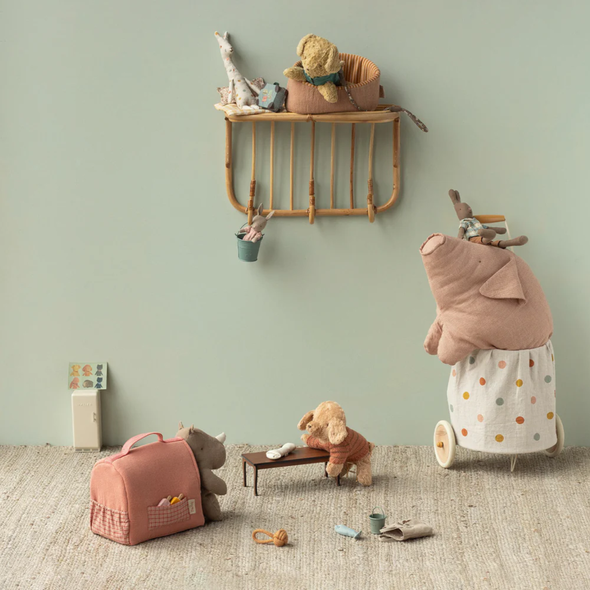 Toy children's room with stuffed toys and a shelf against a light green wall.  Animals include dogs, a pig, rhino and giraffe.