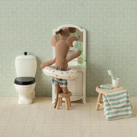 Miniature bathroom setup with a mouse wearing a floatie, a vanity, toilet, and sink.