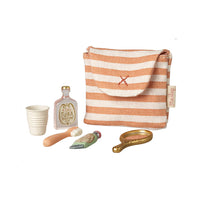 Toy striped bag with miniature accessories on a white background.