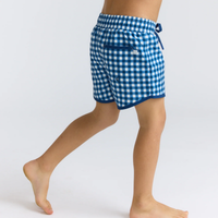 Blue and white checkered boardie shorts worn by a person on a white background