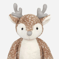 A plush stuffed deer toy with a brown and white spotted pattern, gray antlers, and a white snout, photographed against a plain light gray background.