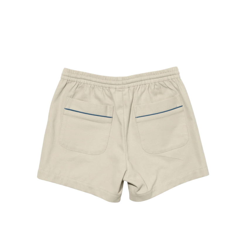 Beige shorts with an elastic waistband, two large back patch pockets, and thin blue piping accents along the pocket edges, shown from the back on a white background.