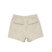 Beige shorts with an elastic waistband, two large back patch pockets, and thin blue piping accents along the pocket edges, shown from the back on a white background.