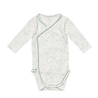 A long-sleeve baby crossbody wrap bodysuit in white with a light green speckled pattern and green piping, laid flat on a white background.