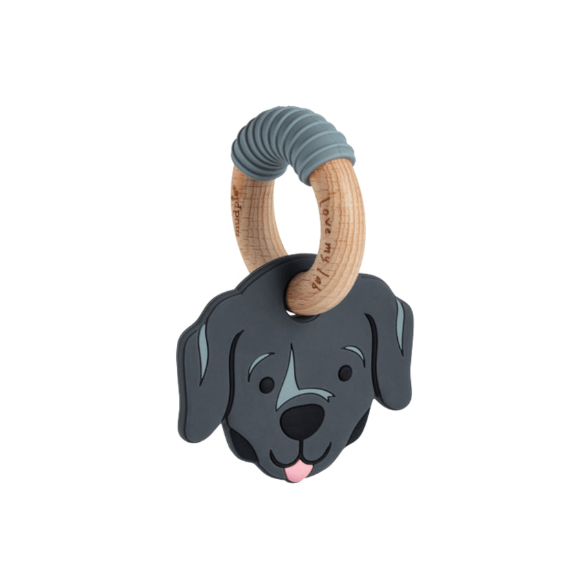 A dog-shaped baby teething toy featuring a dark gray silicone dog head with a pink tongue and a natural wood ring handle wrapped in a gray ribbed sleeve, shown on a plain white background.
