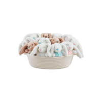 Basket with multi-color plush bunny rattles on a white background.