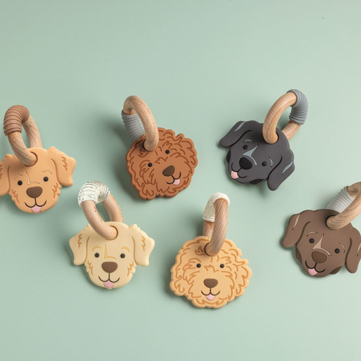 Set of dog-themed baby teething rings on a light green background.