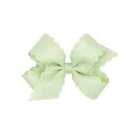 Seafoam bow with scalloped edges on a white background.
