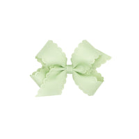 Seafoam green bow with scalloped edges on a white background.