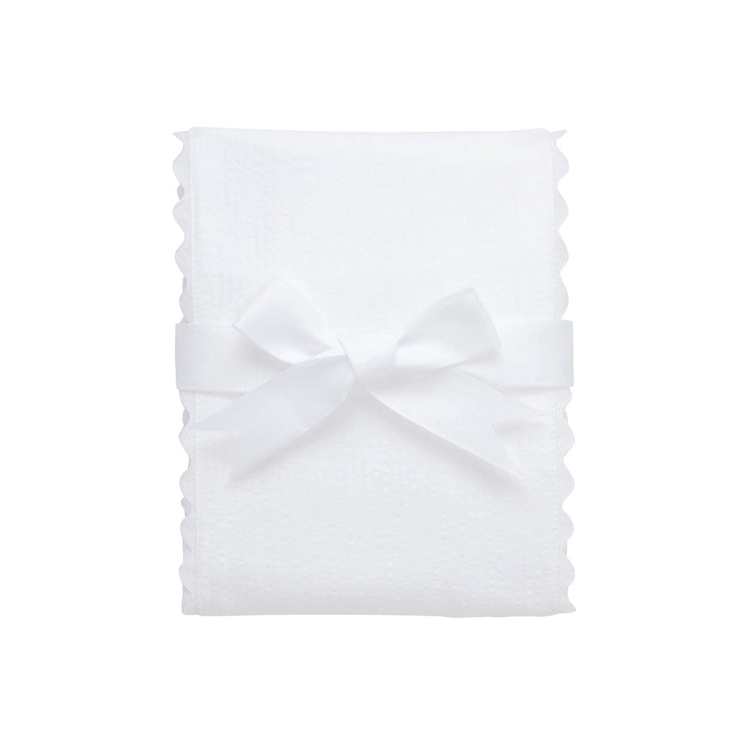 White burp cloth with a bow on a white background.