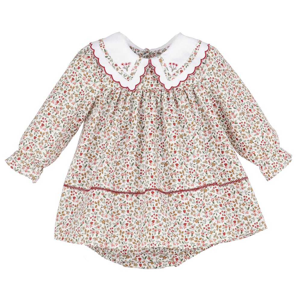 A long-sleeve dress with a dense red, green, and yellow floral print on a cream background, featuring a white Peter Pan collar with red scalloped trim.