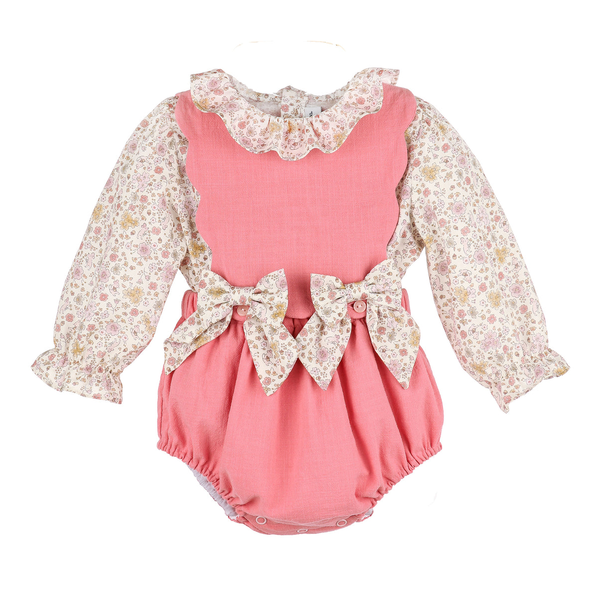 Pink baby romper with floral long-sleeve top and bows on the front on a white background.