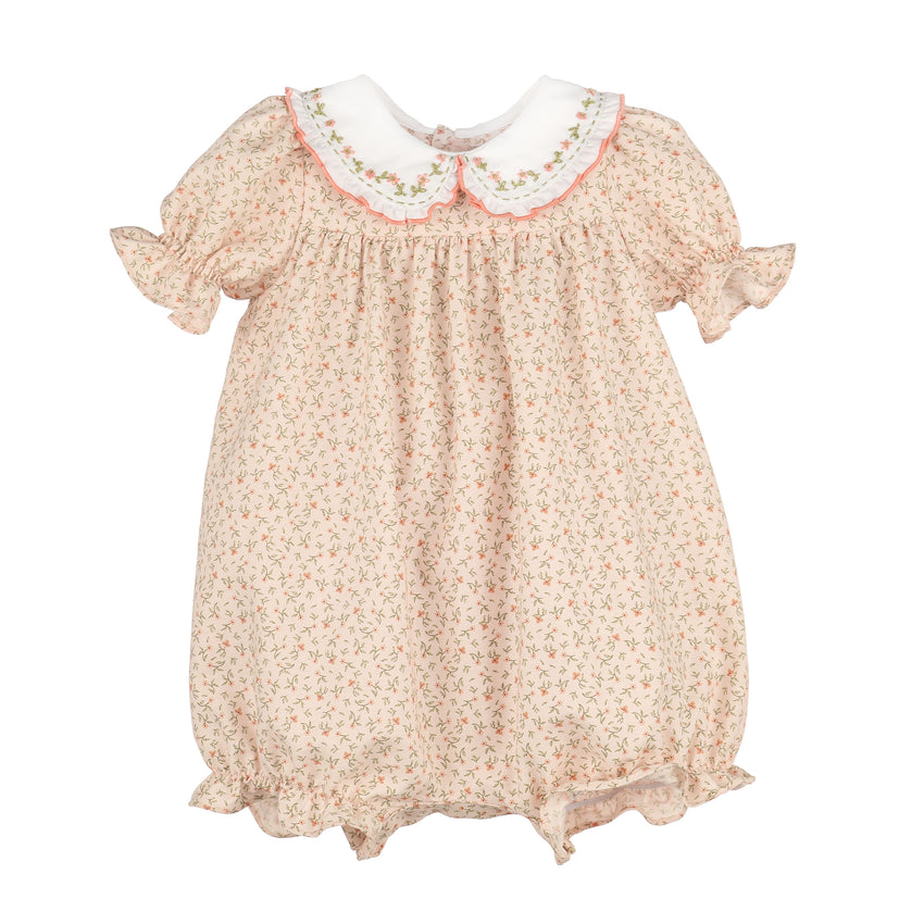 A romper in a light orange floral print with a white Peter Pan collar featuring embroidered details, set against a plain white background.