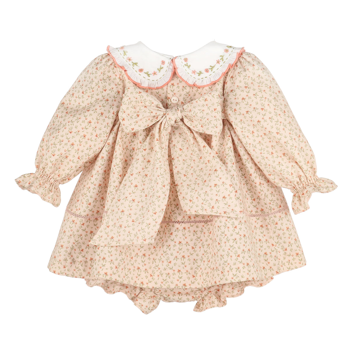 A girl's long-sleeve dress with a small floral print in beige, pink, and green, featuring a large bow at the center back, a white Peter Pan collar with pink trim, and ruffled cuffs and hem.
