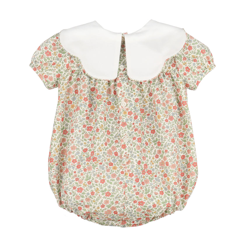 A girl's short-sleeve blouse featuring a white Peter Pan collar and a delicate floral print bodice with a ruffled hem.