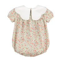 A girl's short-sleeve blouse featuring a white Peter Pan collar and a delicate floral print bodice with a ruffled hem.