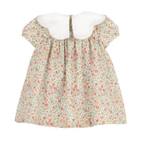 A short-sleeve dress with a dense floral print in red, pink, and green on a light beige background, featuring a contrasting solid white rounded neckline.