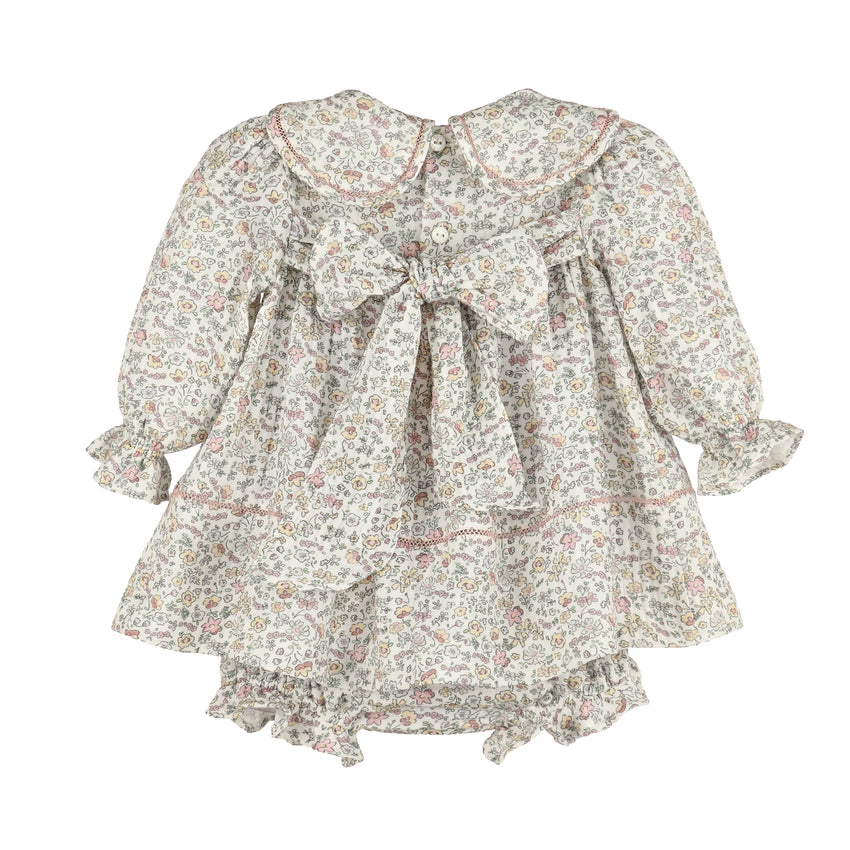 Back of floral dress with long sleeves and a big bow on a white background.
