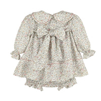 Back of floral dress with long sleeves and a big bow on a white background.