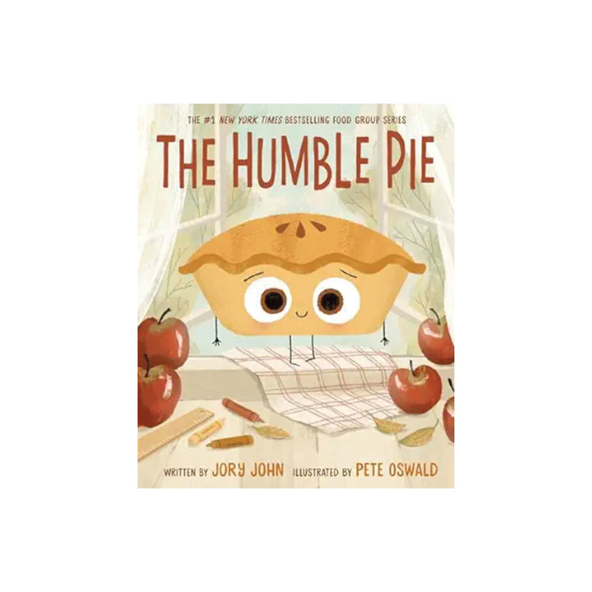 The Humble Pie book cover featuring a cute illustrated pie character with large eyes and small limbs, surrounded by red apples and baking props on a cream background.