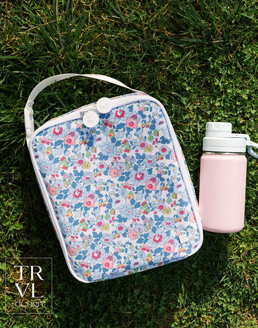 Floral-patterned pouch and pink water bottle on grass