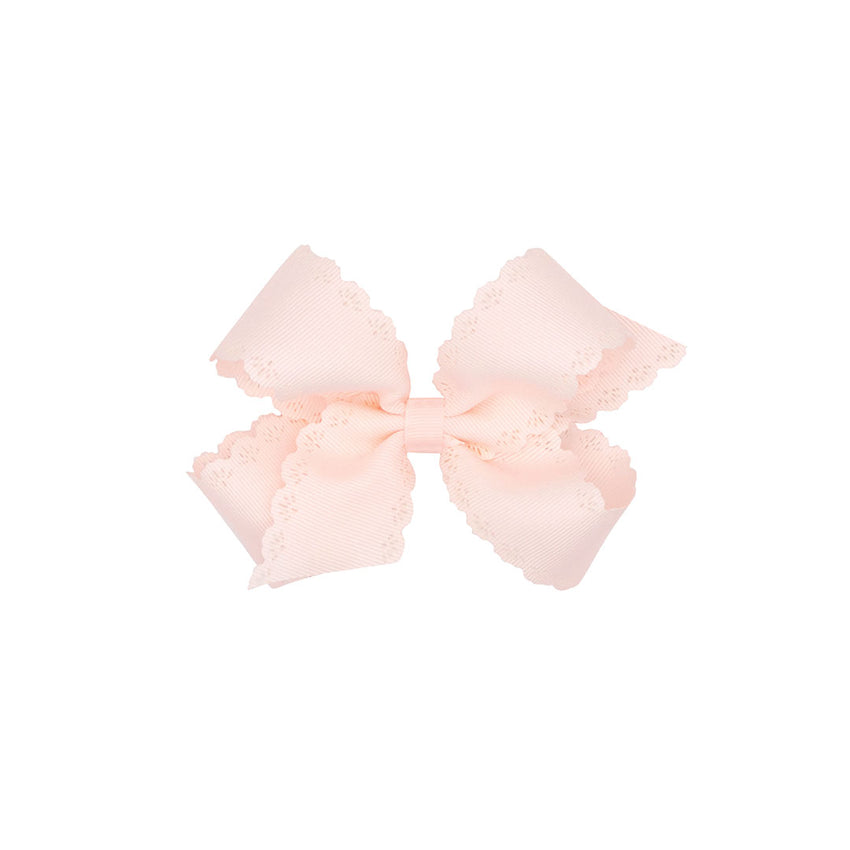 Rose pink colored bow with scalloped edges on a white background.