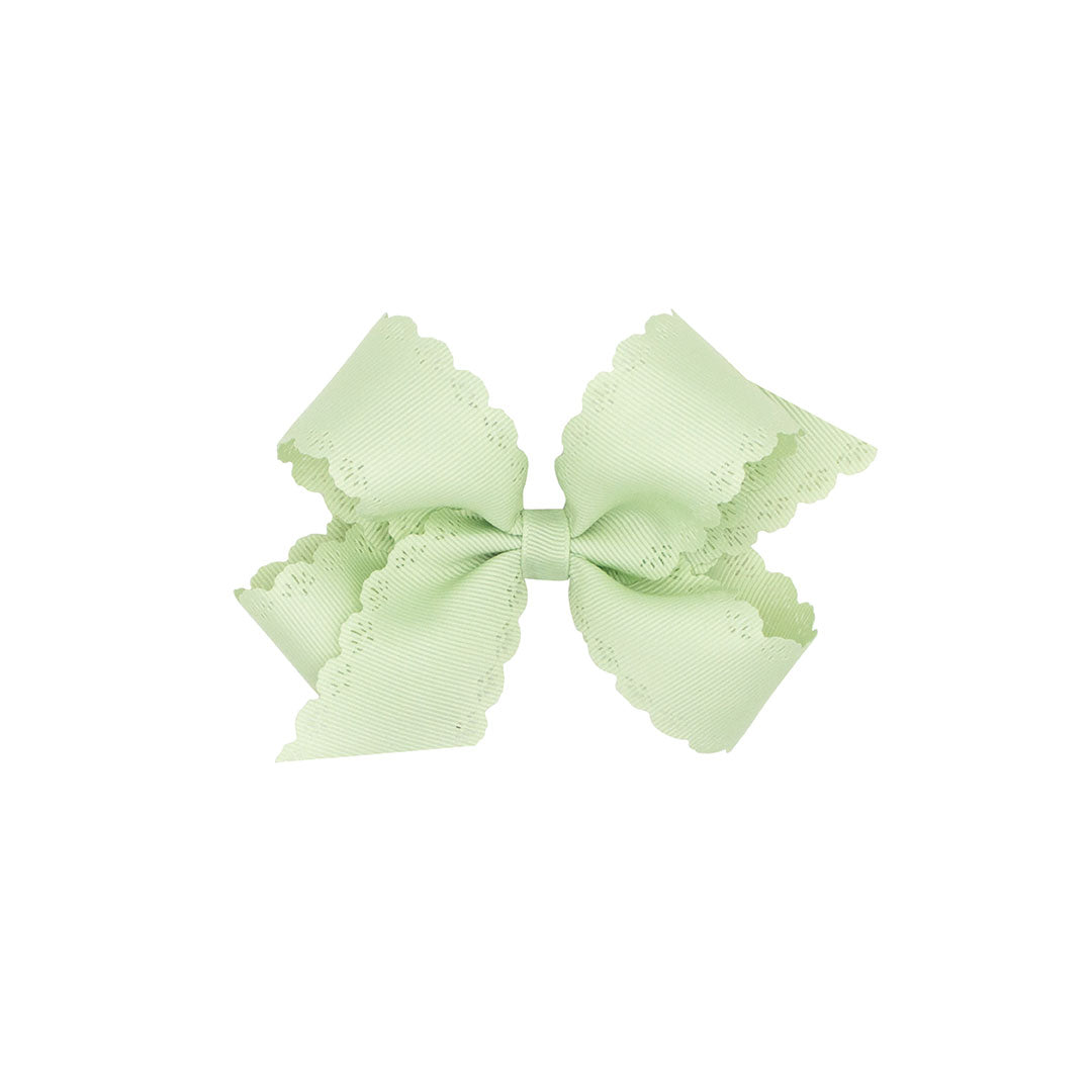 Seafoam green bow with scalloped edges on a white background.