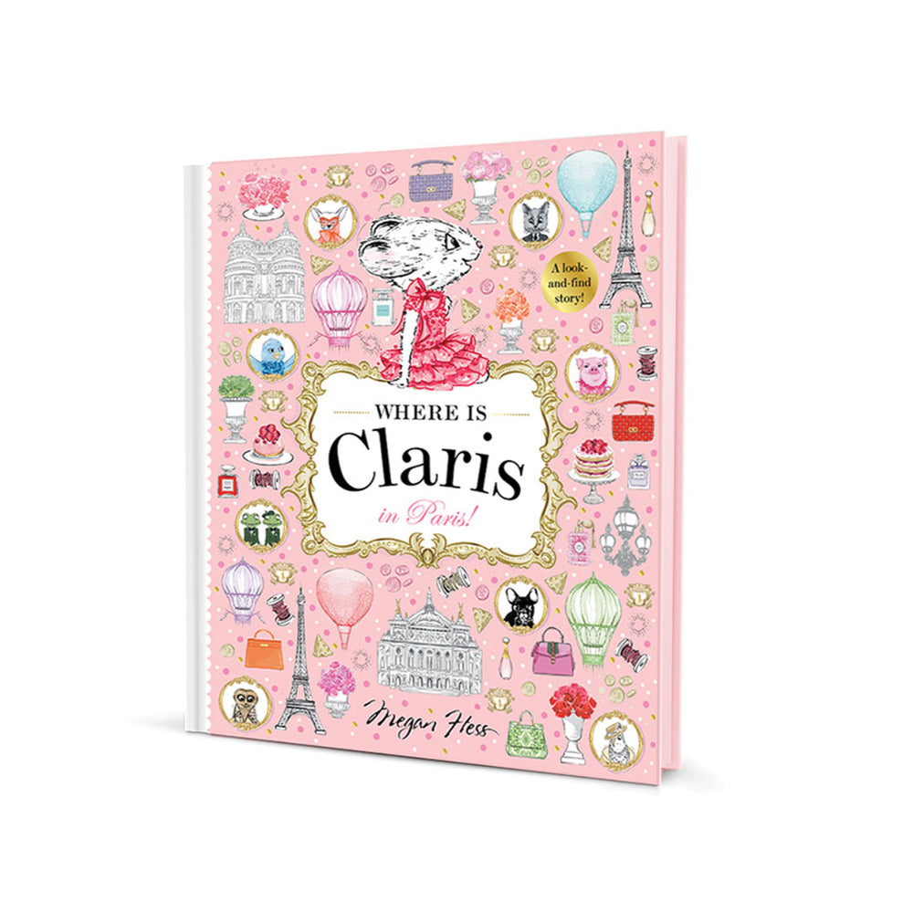 A pink hardcover book titled 'Where Is Claris in Paris!' with illustrated Parisian motifs such as the Eiffel Tower, hot air balloons, and postcards on the cover, photographed on a clean white background.